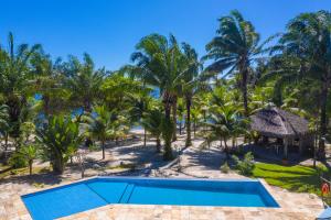 uma vista aérea de um resort com uma piscina e palmeiras em Éden do Catu em Aquiraz