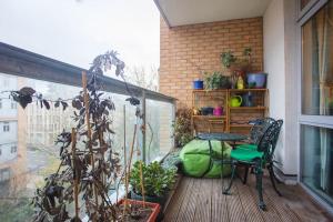 a balcony with a table and chairs and a plant at Unique & Welcoming 2BD Flat in Limehouse in London
