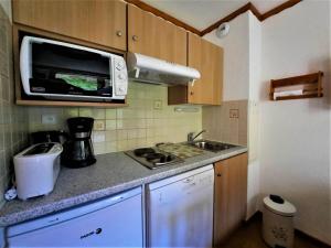 a small kitchen with a sink and a microwave at Charmant studio cabine 4 pers. aux Bruyères, pied des pistes, animaux permis - FR-1-452-7 in Les Menuires +7 photos