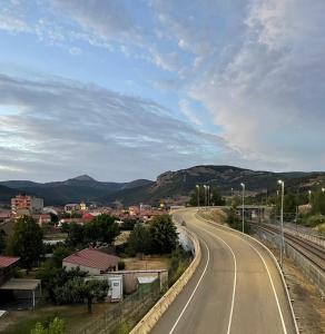 an empty road in a town with mountains in the background at La Milana in La Robla