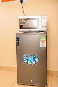 a microwave sitting on top of a refrigerator at A&T Luxury Homestays in Kisii