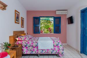 a bedroom with a bed and a window at Éden do Catu in Aquiraz