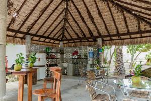 a large pavilion with tables and chairs and a refrigerator at Éden do Catu in Aquiraz