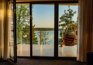 a room with a swing and a view of the water at Willa Port in Ostróda