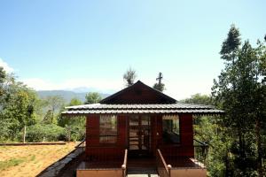 a small cabin with chairs and a roof at Red Panda Jungle Camp - A Unit of Davinchi Homes Pvt Ltd in Gyalzing