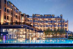 a large building with a pool in front of it at Wellness- & Sporthotel Jagdhof in Röhrnbach