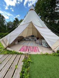 uma grande tenda com um deque de madeira na relva em Tipi telk Jantsu talus 
