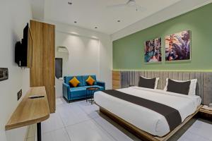 ein Hotelzimmer mit einem Bett und einem blauen Sofa in der Unterkunft HOTEL LEE PLATINUM in Ahmedabad
