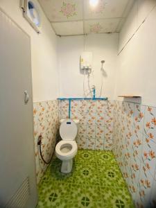 ein Badezimmer mit WC und grünem Boden in der Unterkunft Baan phuwamin in Ko Lanta