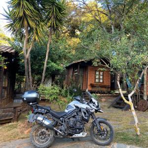 une moto garée devant une maison dans l'établissement Abrigo Cipó, à La Serra do Cipo