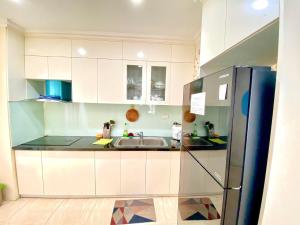 una cucina con armadi bianchi e frigorifero in acciaio inossidabile di new life tower a Ha Long
