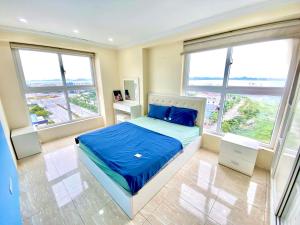 una camera da letto con letto con lenzuola e finestre blu di new life tower a Ha Long