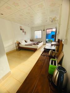 Großes Zimmer mit einem Bett und einem Tisch in der Unterkunft Baan phuwamin in Ko Lanta