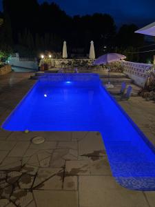 una piscina azul por la noche con sombrilla en Studio Squirrel en La Nucía