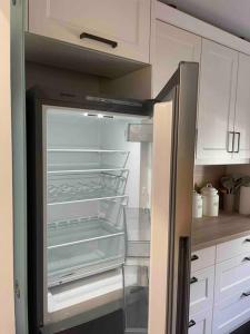 a refrigerator with its door open in a kitchen at Moderne Wohnung in der nähe vom Parndorf Outlet! in Bruckneudorf