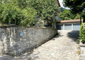 a stone retaining wall next to a garage at Locanda del Buon Cammino in Chiusi della Verna