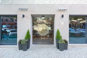 un front de magasin avec deux plantes en pot devant lui dans l'établissement Holiday Inn Express - Lisbon - Plaza Saldanha, an IHG Hotel, à Lisbonne