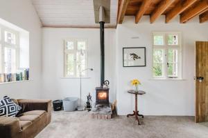 een woonkamer met een bank en een houtkachel bij Wye Riverside Lodge in Llandrindod Wells