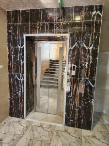 a bathroom with a mirror and a marble wall at dream house hotel in Jerash