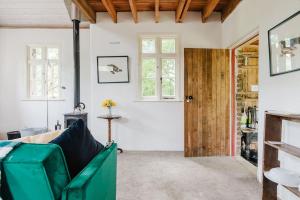 a living room with a green couch and windows at Wye Riverside Lodge in Llandrindod Wells