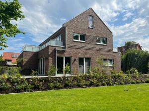 a brick house with a lawn in front of it at Apartmenthaus Emily by POLY Hohwacht in Hohwacht