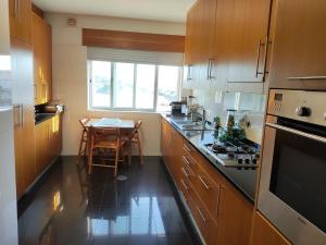 a kitchen with a table and a stove top oven at Furadouro Pool&Beach Apart in Ovar