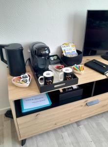 a table with a coffee maker and food on it at Studio plage, vue mer et dragon, garage pour moto in Calais