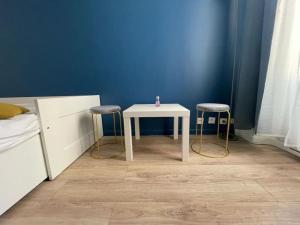 a white table and two stools in a bedroom at Direct access to Paris & the Champs-Elysees in Asnières-sur-Seine