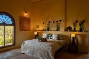 a bedroom with a bed and a window with vases at Luna Laguna in Kalpitiya