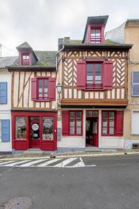 un edificio con puertas rojas y ventanas rojas en Gite des Gargouilles, en Saint-Valery-sur-Somme
