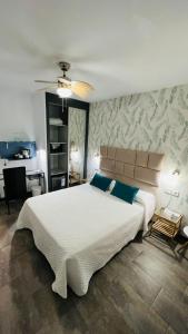 a bedroom with a large white bed with blue pillows at Bajondillo Beach Cozy Inns in Torremolinos