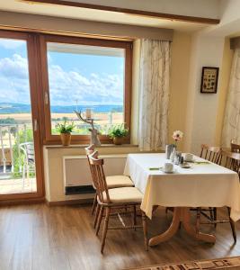 a dining room with a table and a large window at Landhaus Kürrenberg in Mayen