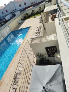 - une vue sur la piscine et un parasol dans l'établissement Furadouro Pool&Beach Apart, à Ovar