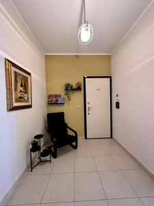 a waiting room with a black chair and a door at Casa moderna a Torino in Turin