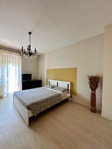 a large bedroom with a bed and a chandelier at Casa moderna a Torino in Turin