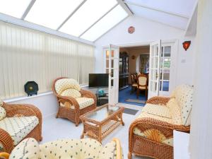 a conservatory with wicker chairs and a television at Pass the Keys Family Home With Parking Next To Heaton Park in Manchester
