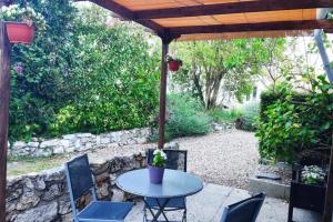 a table and chairs under a wooden umbrella at Petit cottage in Saint-Pierre-la-Garenne