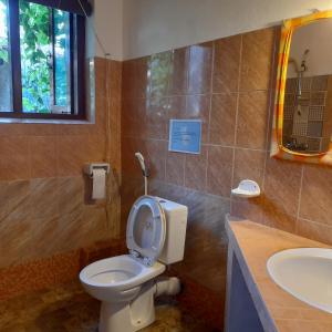 a bathroom with a toilet and a sink at Shoba Traveller's Tree in Galle