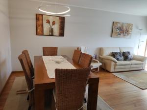 - une salle à manger avec une table, des chaises et un canapé dans l'établissement Furadouro Pool&Beach Apart, à Ovar