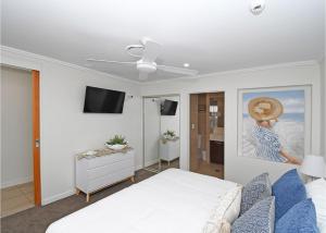 um quarto com uma cama e uma televisão de ecrã plano em Oceanviews at Hervey Bay resort em Urangan