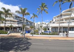 una calle vacía frente a un edificio con palmeras en Oceanviews at Hervey Bay resort en Urangan