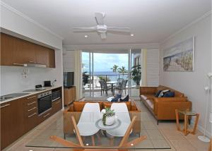 cocina y sala de estar con mesa y sofá en Oceanviews at Hervey Bay resort en Urangan
