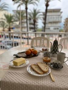 een tafel met kaasbrood en fruit en koffie erop bij En busca del tiempo perdido in Tavernes de la Valldigna