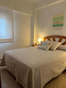 een slaapkamer met een groot wit bed met 2 kussens bij En busca del tiempo perdido in Tavernes de la Valldigna