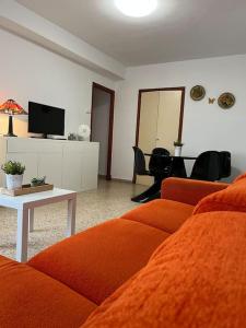 een woonkamer met een oranje bank en een tafel bij En busca del tiempo perdido in Tavernes de la Valldigna