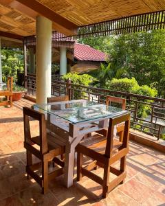 a glass table and chairs on a patio at The Roar Resort in Rāmnagar