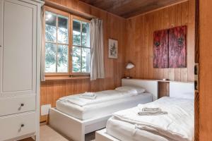 1 dormitorio con 2 camas y ventana en Apartment Zita - GRIWA RENT AG, en Grindelwald