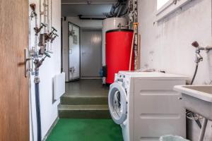 a laundry room with a washing machine and a sink at Apartment Zita - GRIWA RENT AG in Grindelwald