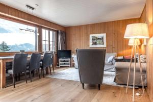 ein Wohnzimmer mit einem Tisch und Stühlen in der Unterkunft Apartment Zita - GRIWA RENT AG in Grindelwald