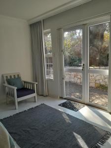 a living room with a chair and sliding glass doors at Sugarbush Accommodation in Vereeniging